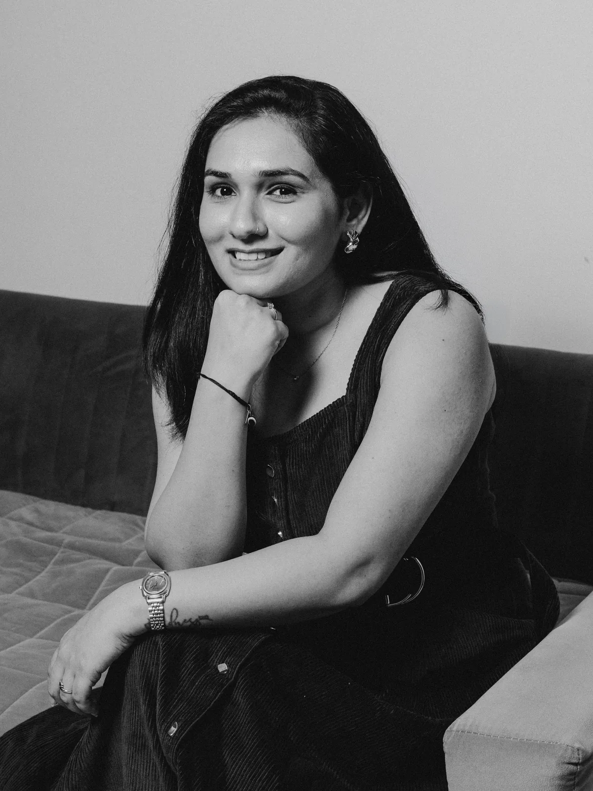 Jasmita Dodia seated, resting her chin on her hand and smiling